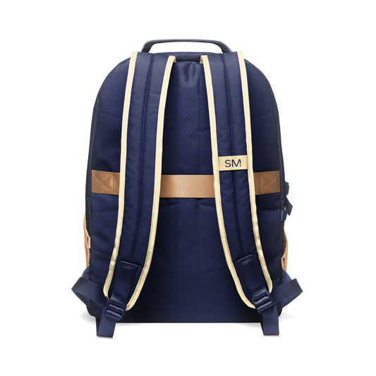 Deep navy blue backpack with tan and cream shoulder straps, handle, and decorative bands