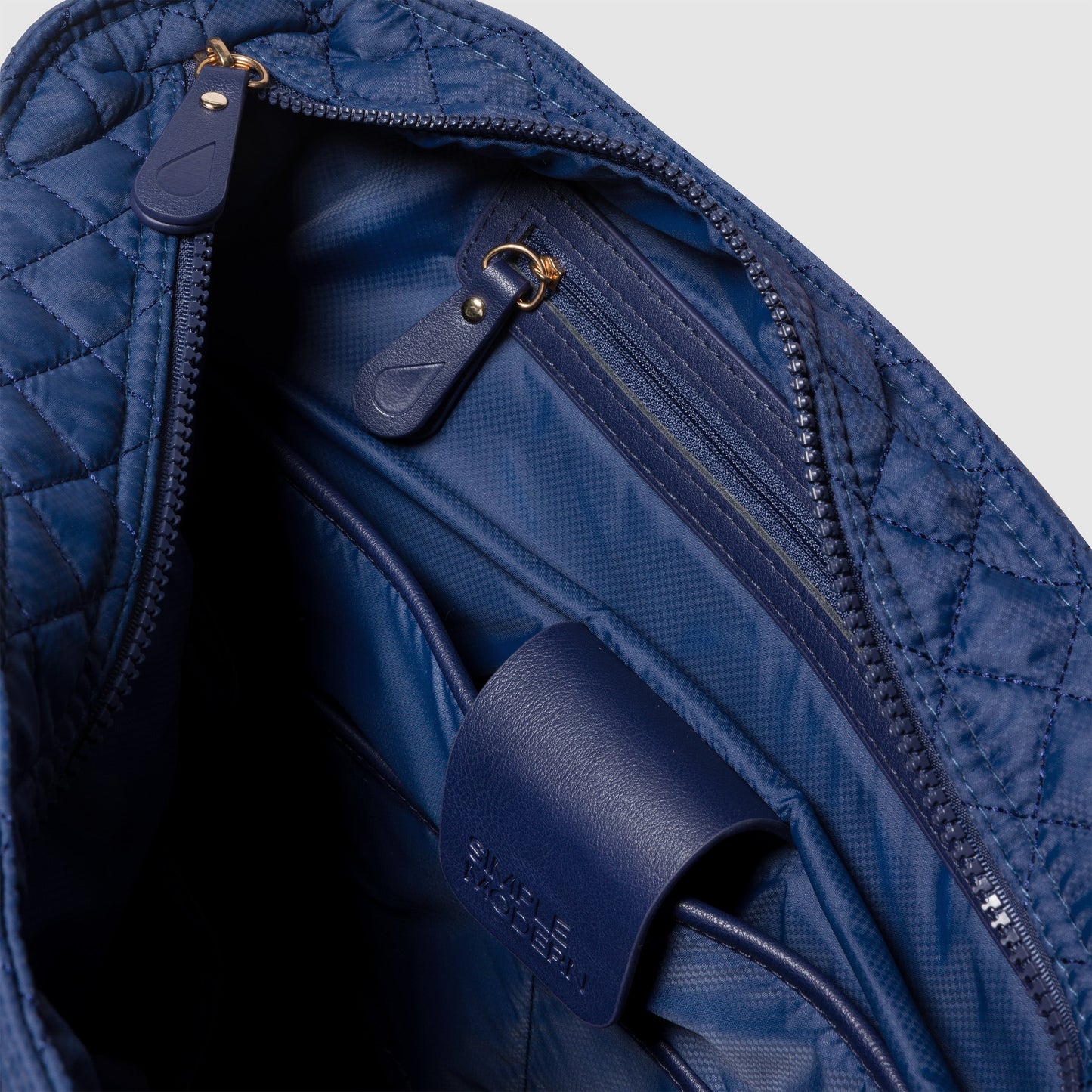 Navy blue quilted bag with diamond pattern exterior and matching navy blue interior lining