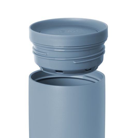 Blue-gray water bottle with detachable lid on white background. Simple modern design in muted slate blue color.