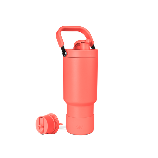Coral-red water bottle with accessories on white background