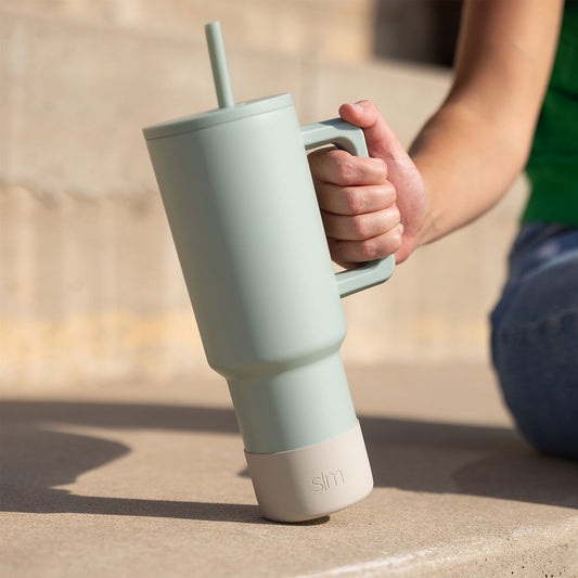 Pale sage green and cream tumbler with cylindrical upper section, featuring a soft muted color palette transitioning from light green to off-white.