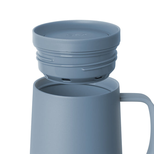 Soft blue-gray muted ceramic vessel with matching lid on white background, contemporary minimalist design