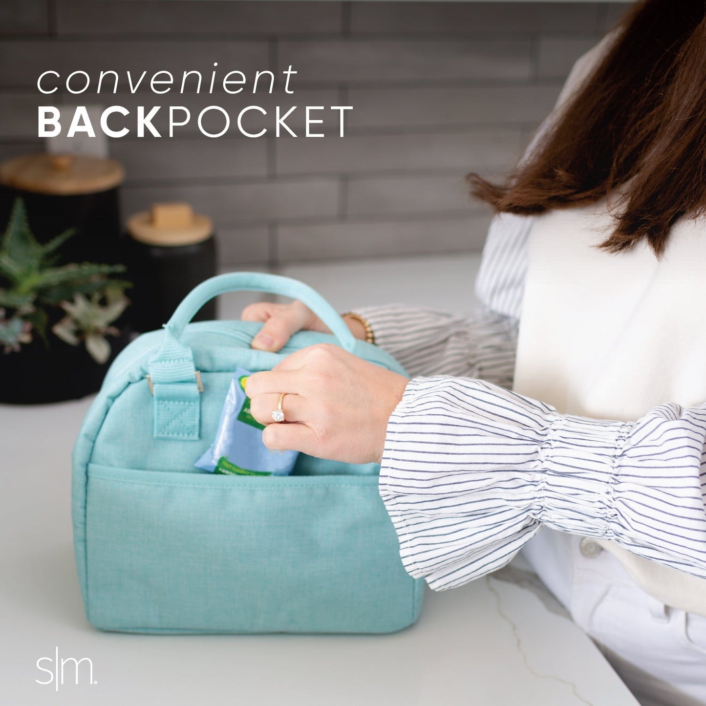 Light aqua pocket backpack displayed against a white and gray brick wall background, showcasing the bag's compact design and soft mint blue color.