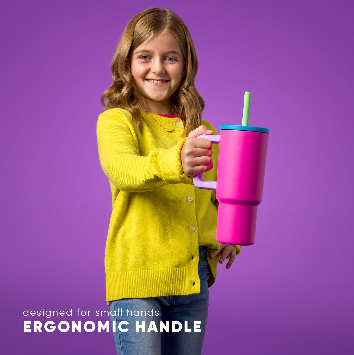 Young girl with blonde wavy hair smiling at camera, wearing bright yellow ribbed cardigan over purple background, holding 24oz Kids Trek water bottle with ergonomic handle