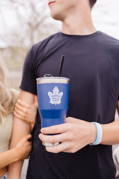 Royal blue insulated tumbler held by person wearing dark navy t-shirt