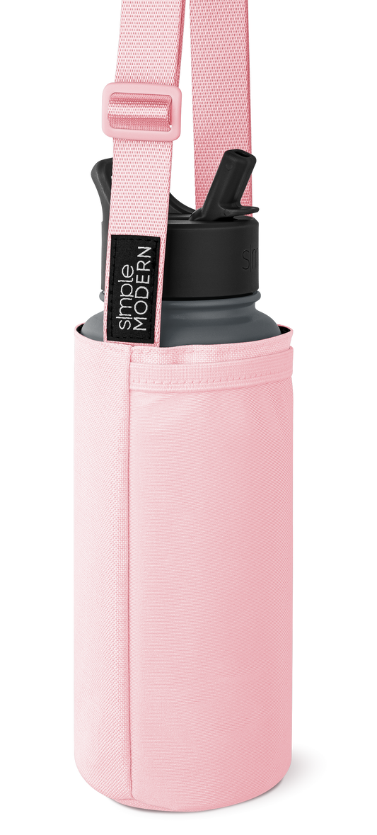Soft pink cylindrical carrying case with charcoal gray and black accents, featuring a matching shoulder strap with webbing texture.