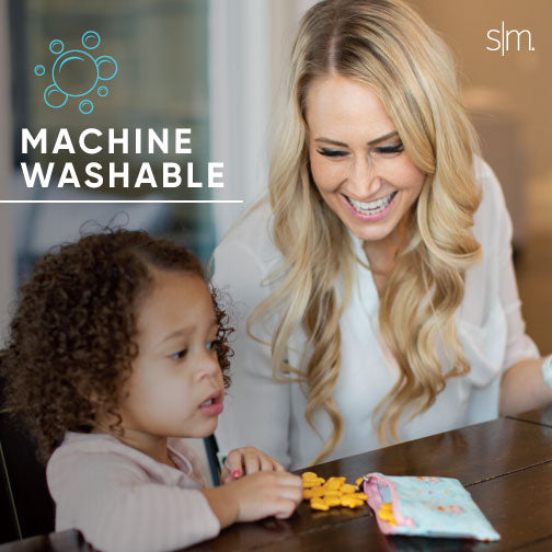 Woman and child holding Ellie Snack Bag against warm beige background, featuring blonde woman in light shirt and child with peachy skin tone in neutral cream and tan setting.