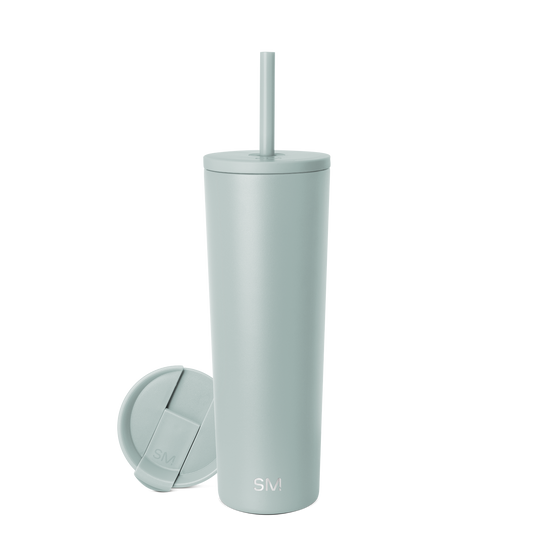 Sage green cylindrical tumbler with matching lid and straw on neutral background