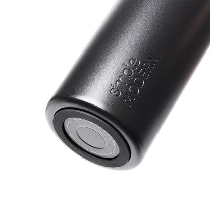 Matte black silicone tumbler with white silicone lid on white background