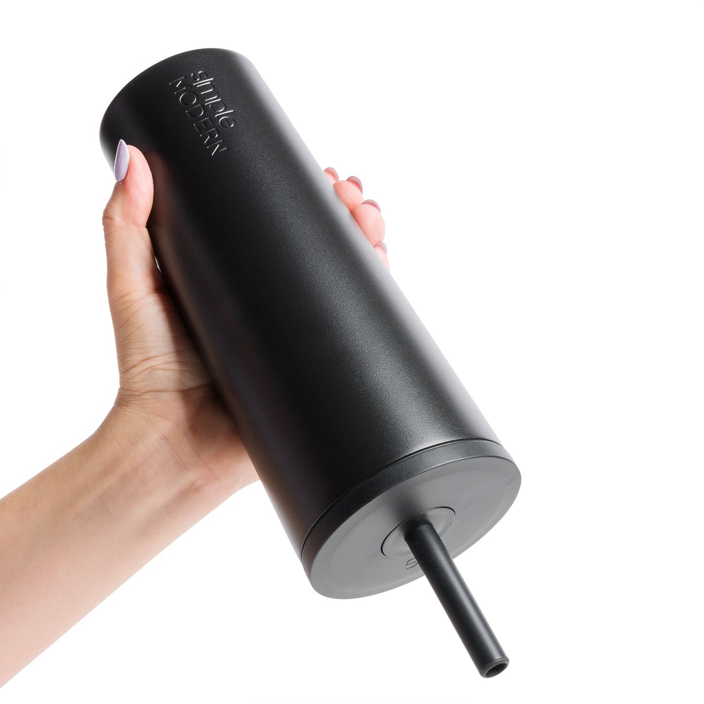 Hand holding a matte black tumbler with gray base, displayed against a white background