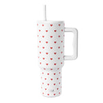 White insulated tumbler with handle and straw featuring a repeating pattern of red hearts in varying sizes.