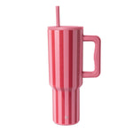 Modern tall tumbler with handle featuring vertical striped pattern in shades of pink, displayed against white background