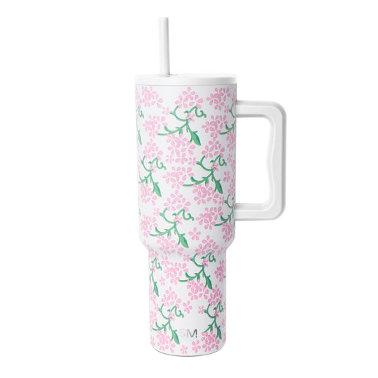 White insulated tumbler with handle and lid featuring pink flowers and green foliage pattern, Simple Modern logo, against white background.
