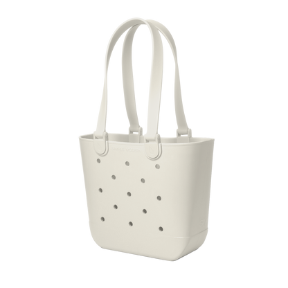 Off-white cream canvas tote bag with scattered gray circular perforations across the front surface