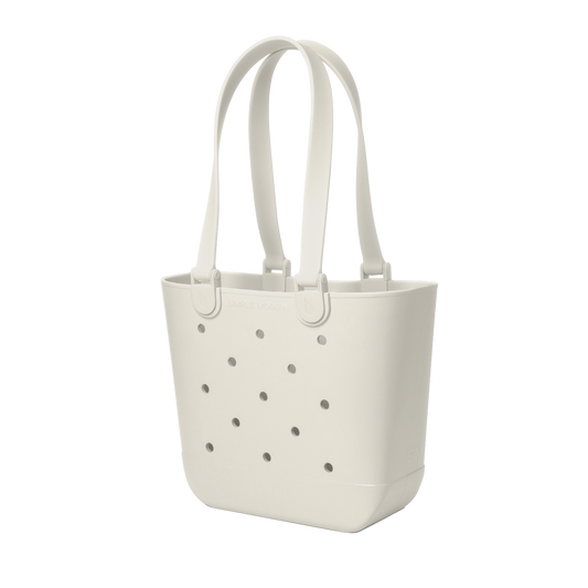 Off-white cream canvas tote bag with scattered gray circular perforations across the front surface