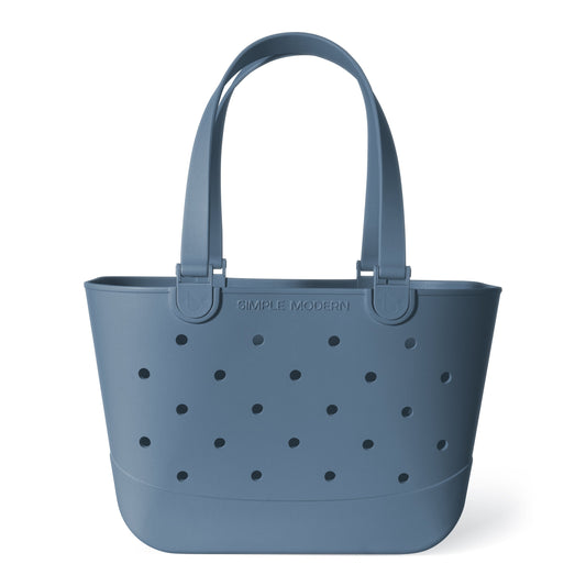 Muted slate blue tote bag with black perforations throughout the design