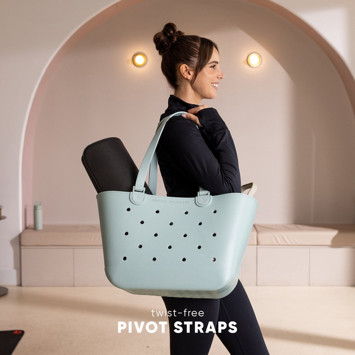 Mint green Simple Modern tote bag with twist-free straps, shown against a neutral beige and taupe background, highlighting the bag's soft seafoam color and ergonomic strap design.