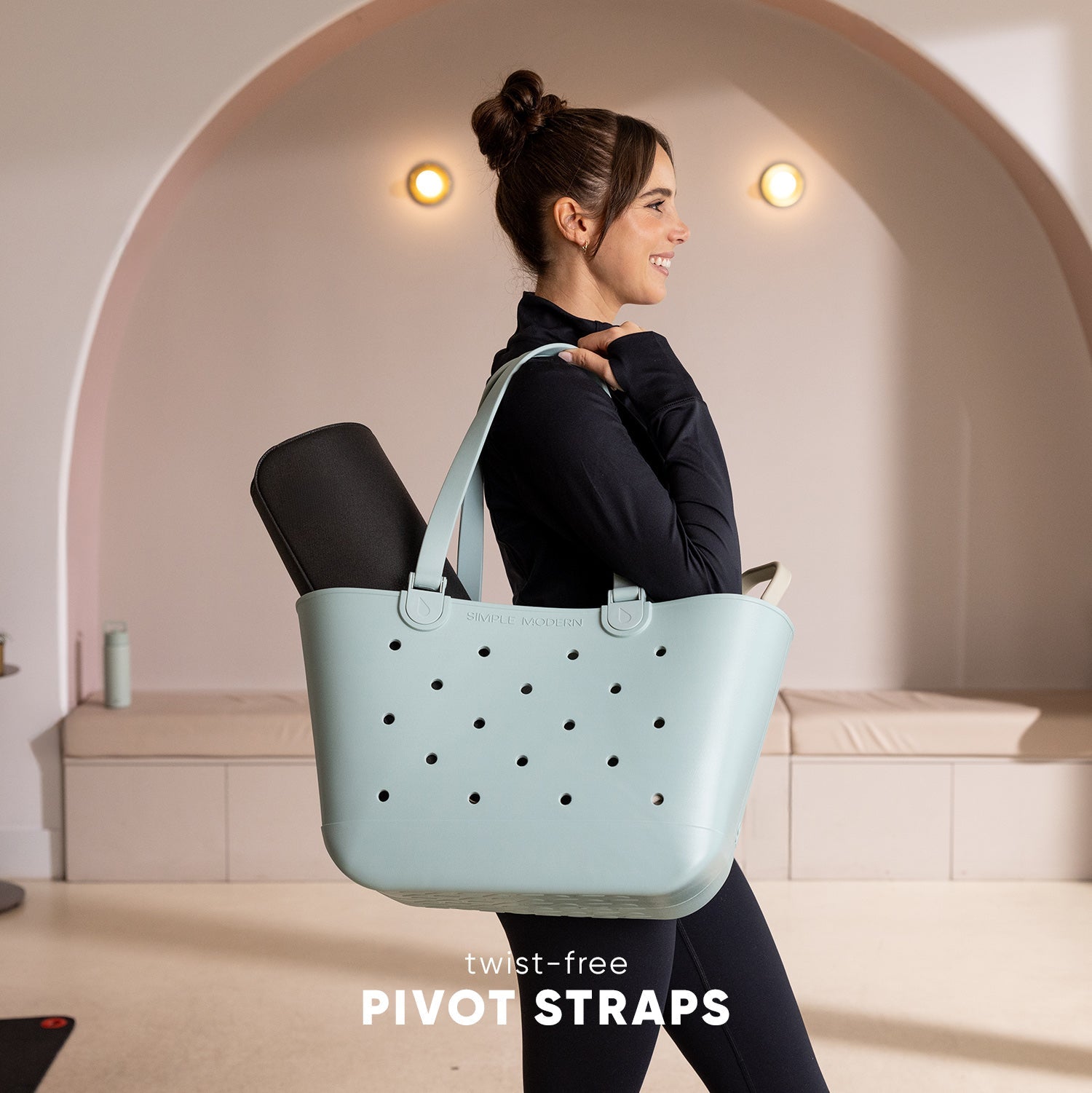 Mint green Simple Modern tote bag with twist-free straps, shown against a neutral beige and taupe background, highlighting the bag's soft seafoam color and ergonomic strap design.