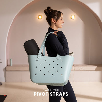 Mint green Simple Modern tote bag with twist-free straps, shown against a neutral beige and taupe background, highlighting the bag's soft seafoam color and ergonomic strap design.