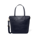 Deep navy modern tote bag with brass-toned metal hardware and handles, displayed flat against a white background