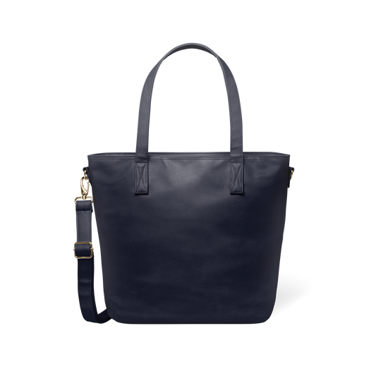 Deep navy modern tote bag with brass-toned metal hardware and handles, displayed flat against a white background