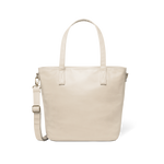 Oatmeal-colored tote bag with gold-toned metal hardware and handles against a white background