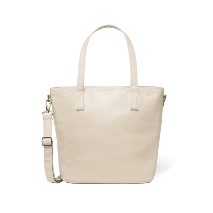 Oatmeal-colored tote bag with gold-toned metal hardware and handles against a white background