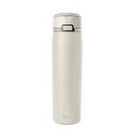 Cream-colored bottle with dark gray accents on neutral beige background