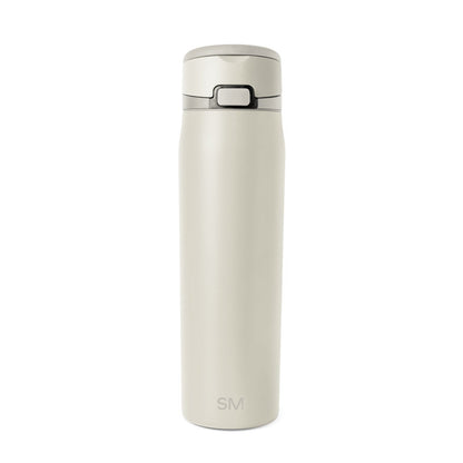 Cream-colored bottle with dark gray accents on neutral beige background