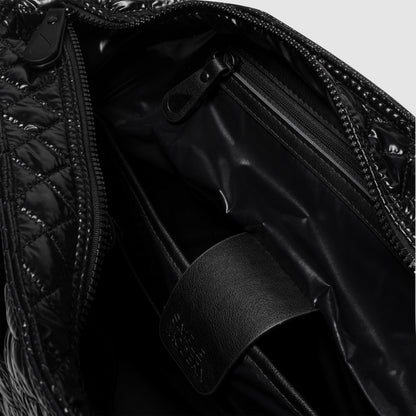 Glossy black interior surface with reflective highlights and deep shadows in monochromatic design