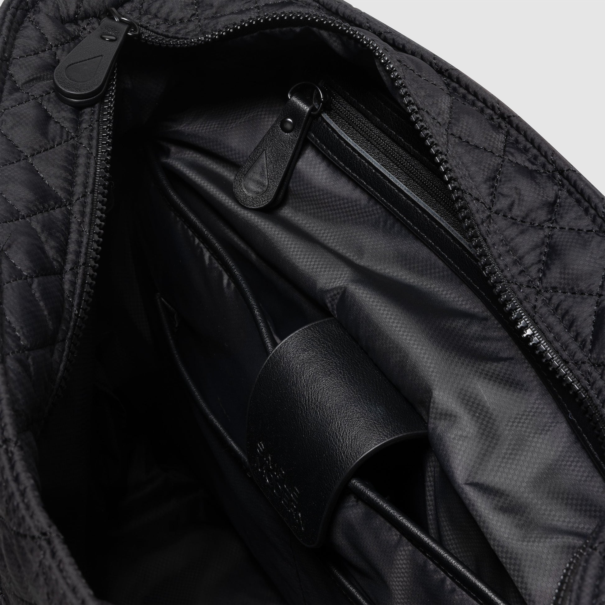 Black and charcoal gray messenger bag interior showing black fabric lining with subtle shadows and light gradations creating depth