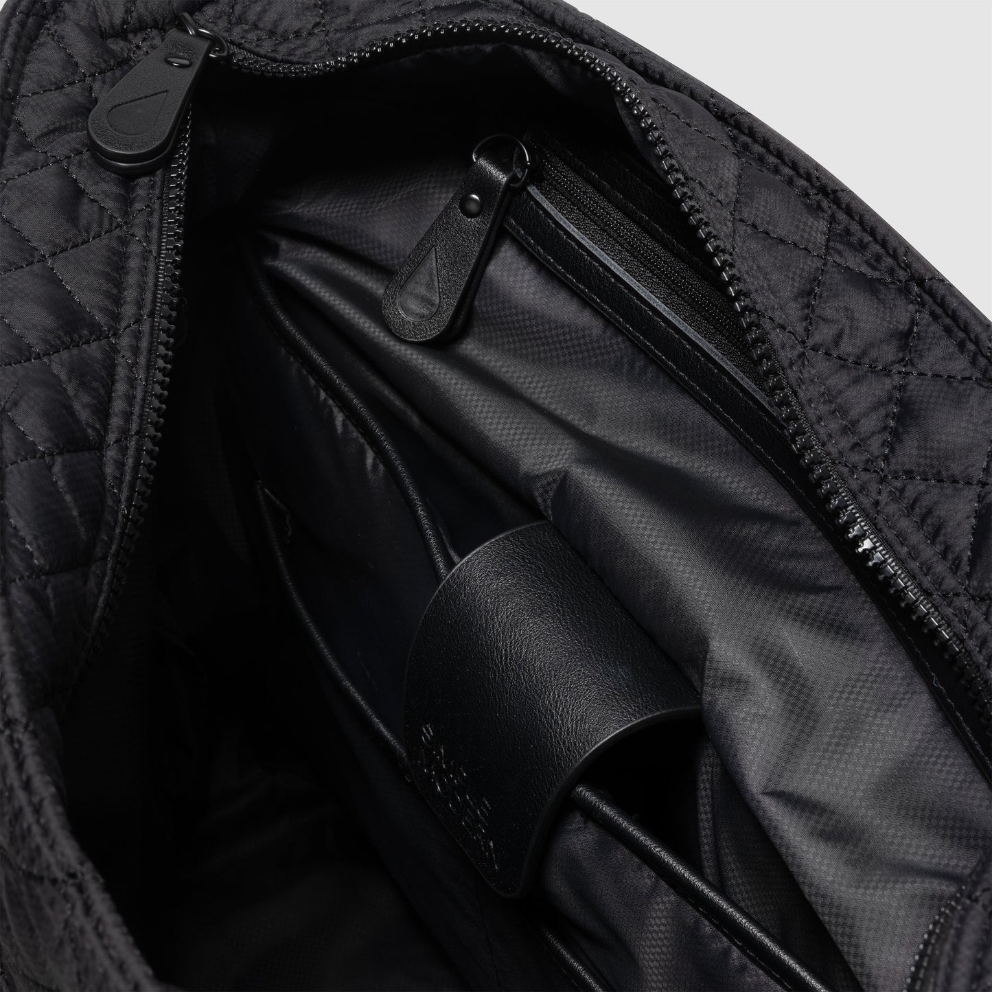 Black and charcoal gray messenger bag interior showing black fabric lining with subtle shadows and light gradations creating depth