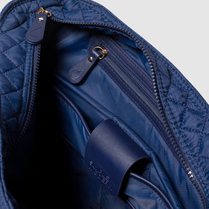 Navy blue quilted bag with diamond pattern exterior and matching navy blue interior lining