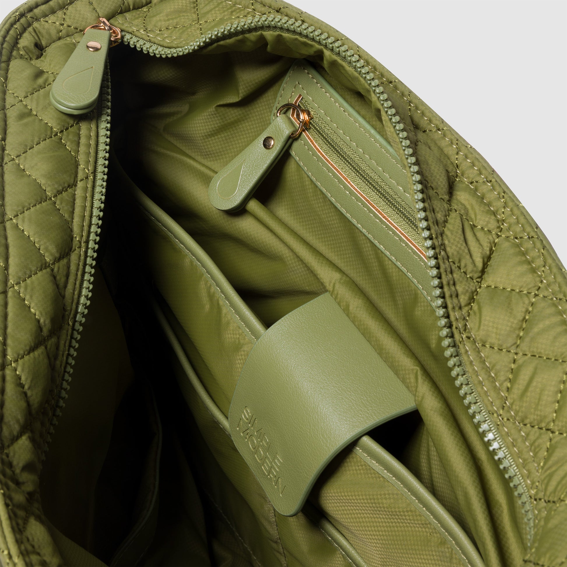Sage green quilted organizer bag interior showing multiple storage pockets and soft muted earth-tone fabric lining