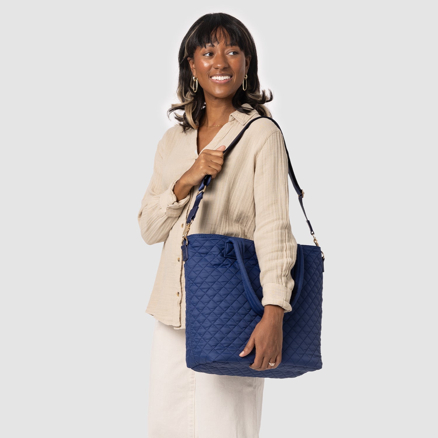 Woman wearing a cream quilted long-sleeve button-up shirt and matching cream pants, standing against a neutral background