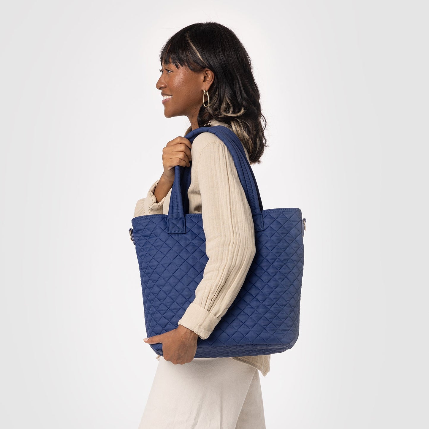 Navy quilted tote bag with cream ribbed long-sleeve top worn by model