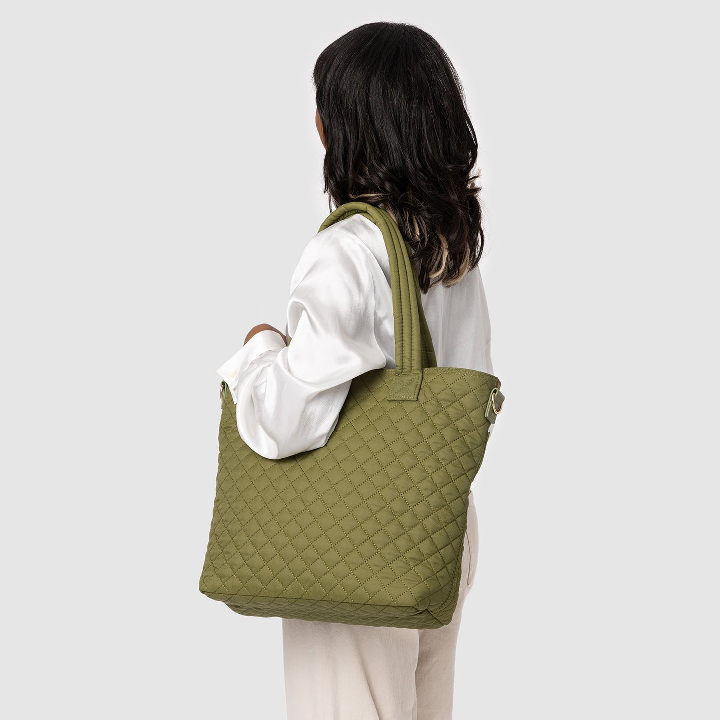 Quilted Harper tote bag in sage green with cream accents, featuring quilted texture detail