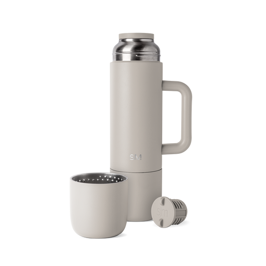 Greige-toned coffee maker with neutral beige-gray exterior walls and soft interior components visible on the lid and brewing chamber