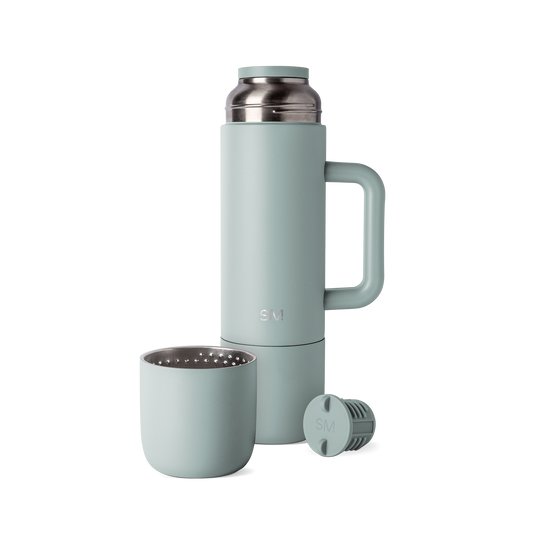 Sage green insulated thermos with matching cap and cup, displayed with handle and accessories against white background