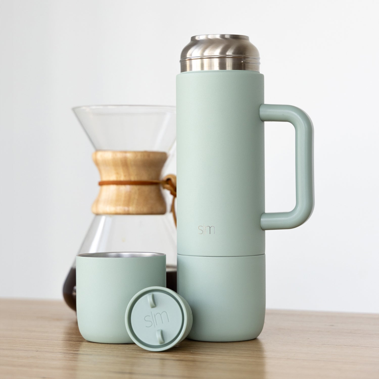 Soft mint green skincare and wellness products arranged with natural wood accents and brushed stainless steel finishes
