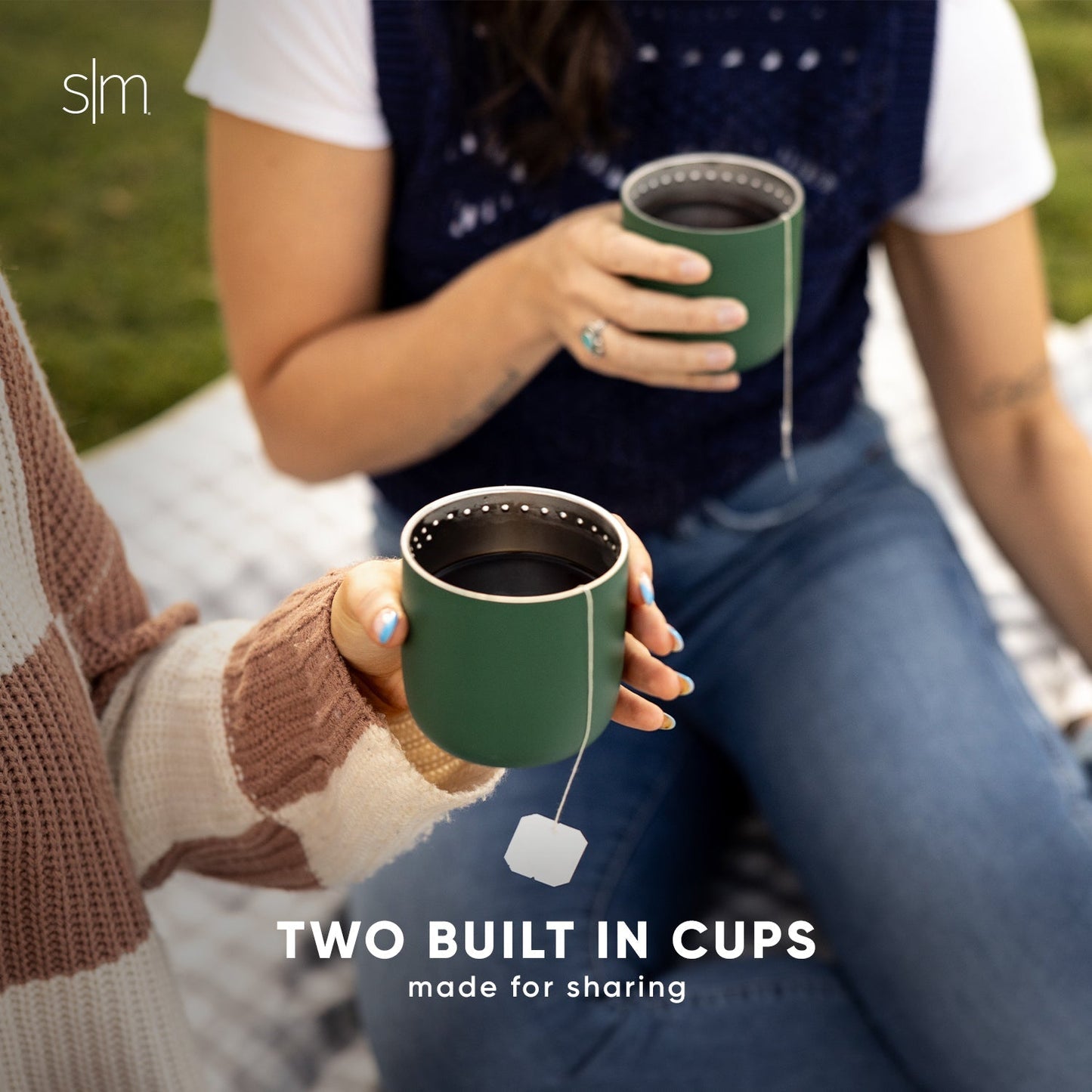 Two sage green ceramic mugs with warm tan and cream accents displayed side by side, featuring a natural, earthy color palette.