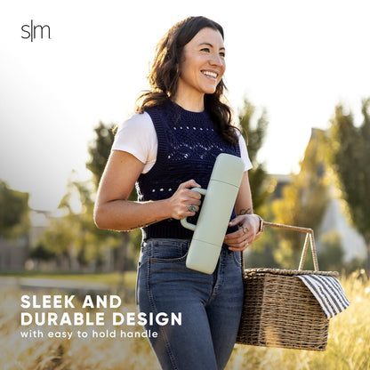 Woman wearing navy blue sleeveless knit vest with open-stitch pattern over white shirt, soft golden-hour lighting with warm white, cream, and sage green tones in background.