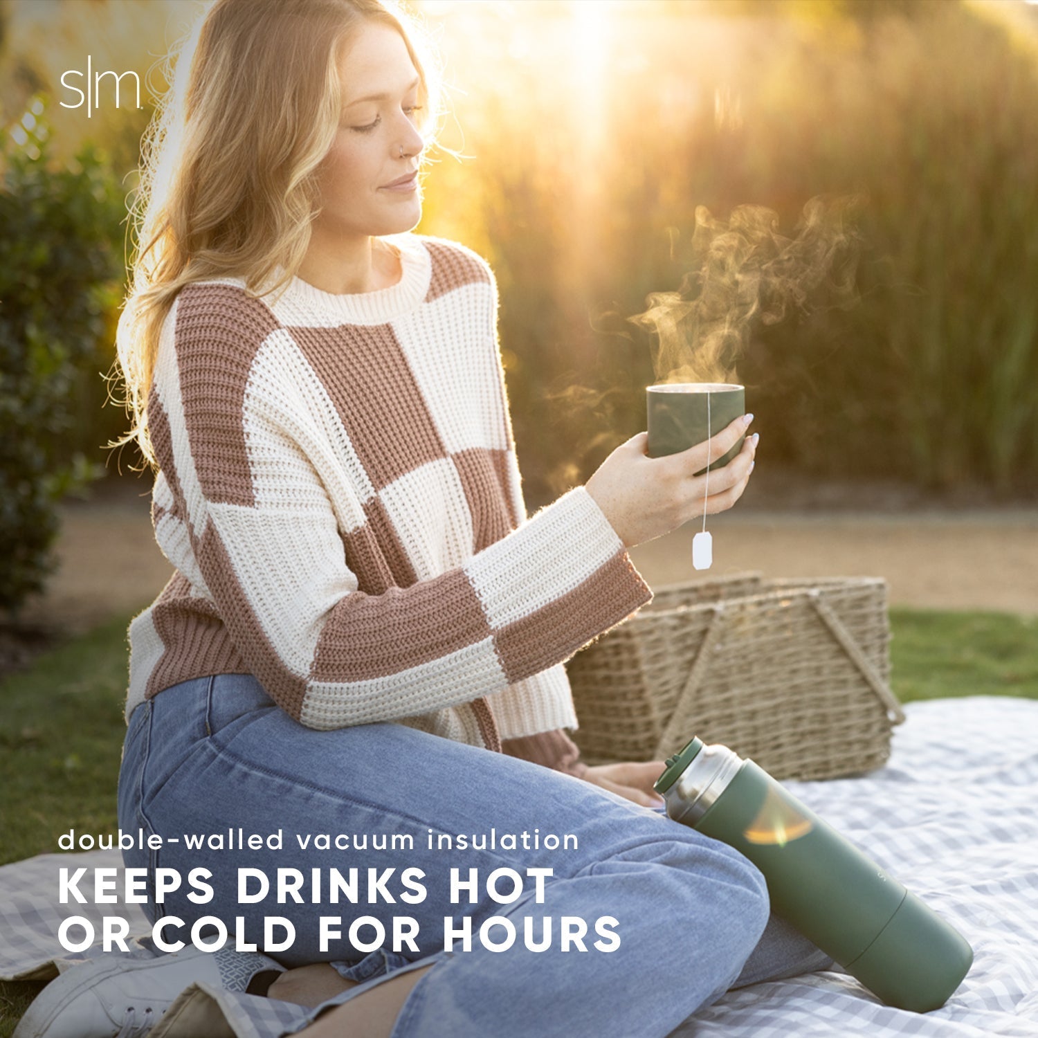 Woman wearing a tan knit sweater and sage green and white insulated jacket, bathed in warm golden sunlight
