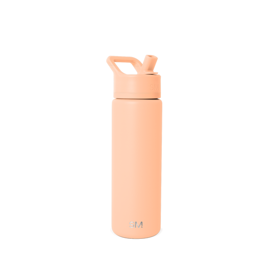 Tall cylindrical water bottle in soft peachy-beige with flip-top cap, angled straw opening, and curved carry handle