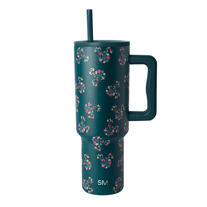 Deep teal drinkware with vibrant floral pattern in hot pink, coral, magenta, white, cream, and yellow accents.