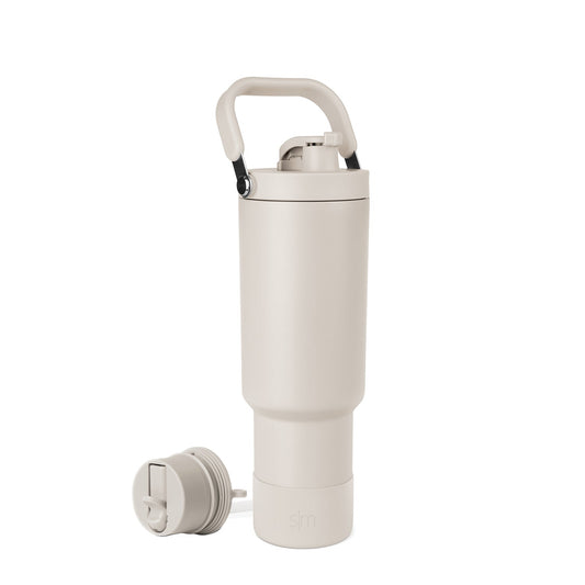 Cream-colored water bottle with black handle accent against neutral background