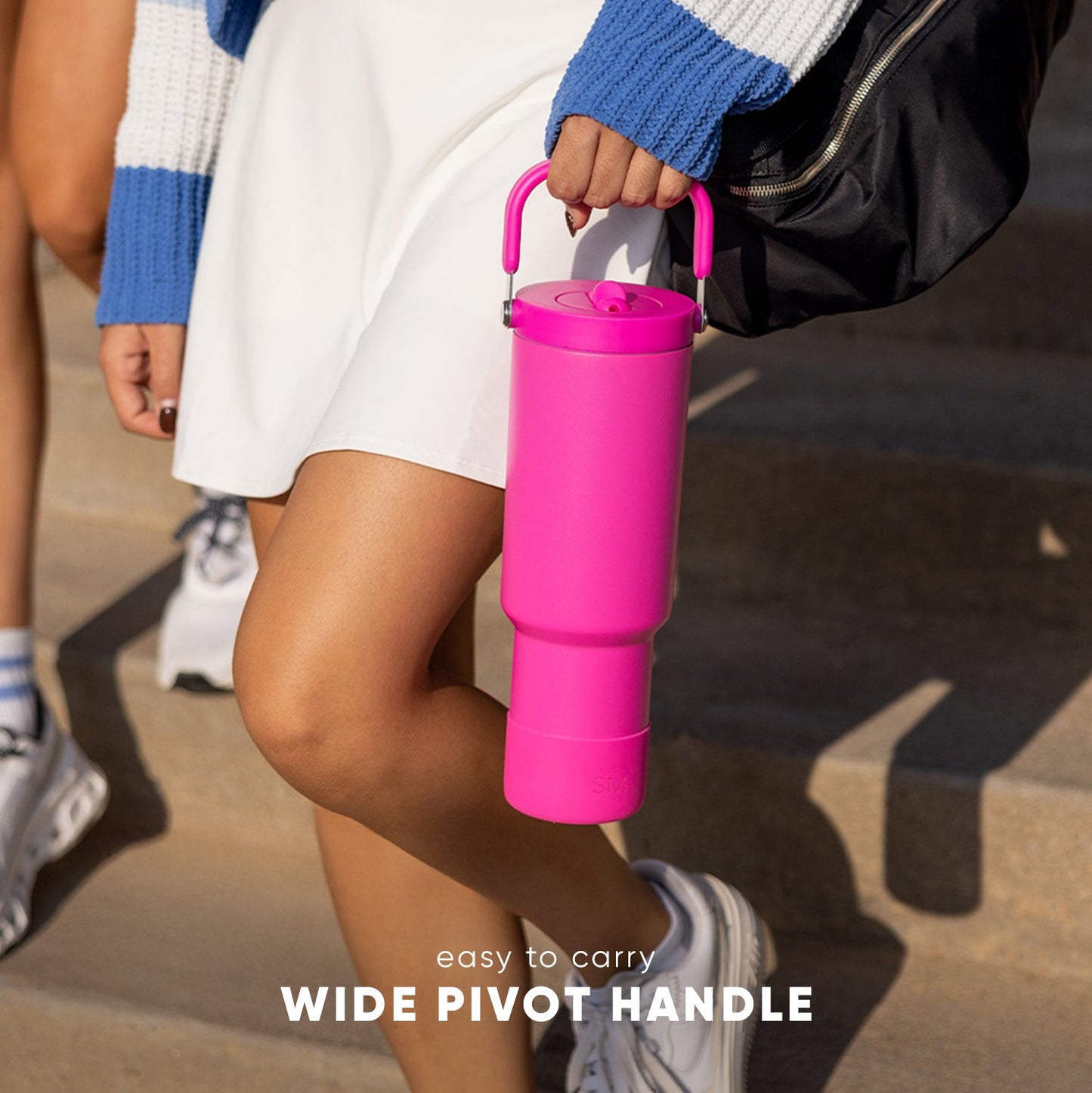Trek Pivot 40 insulated water bottle with pivot handle feature, held in hand, featuring vibrant hot pink exterior against white background.