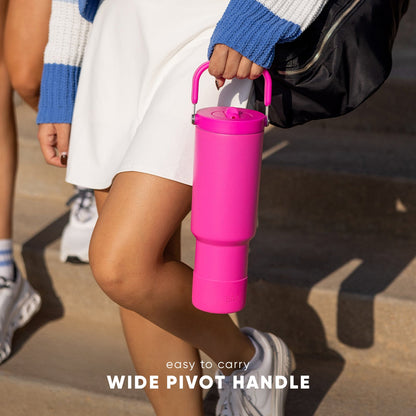 Trek Pivot 40 insulated water bottle with pivot handle feature, held in hand, featuring vibrant hot pink exterior against white background.