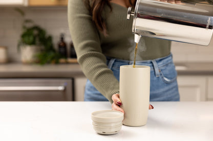 Simple Modern cream and sage drinkware arranged on a neutral countertop with matching background, showcasing insulated bottles and tumblers in warm, earthy tones.